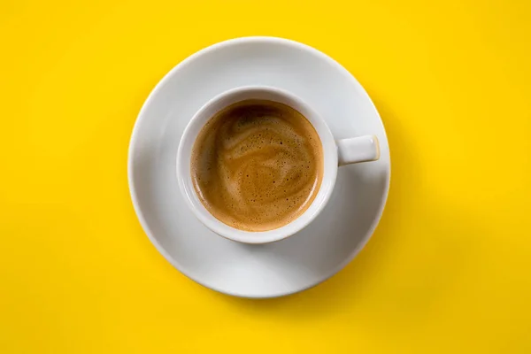 Café negro en una taza sobre un fondo amarillo — Foto de Stock