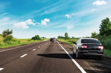 Siyah araba asfalt yolda.