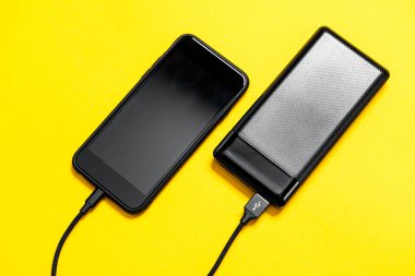 Siyah Güç Bankası akıllı telefonu sarı arka grupta izole etti