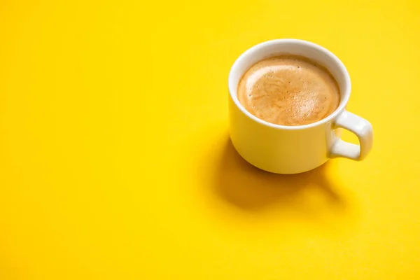 Café negro en una taza sobre un fondo amarillo — Foto de Stock