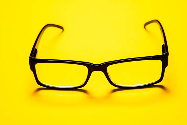 Fekete szemüveg elszigetelt sárga háttér — Stock Fotó
