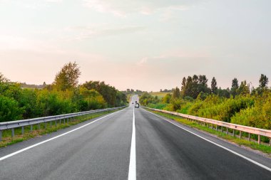 Asfalt yollar ve mavi gökyüzünün altındaki dağlar