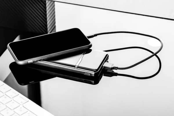 Powerbank charge smartphone isolé sur fond noir — Photo