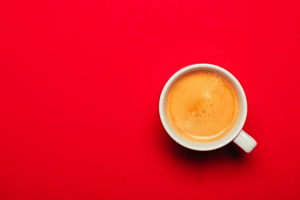 Café negro en una taza sobre fondo rojo — Foto de Stock