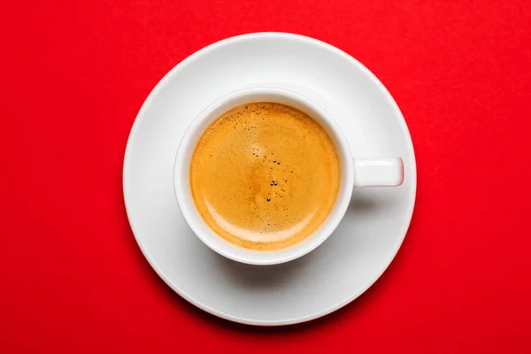 Schwarzer Kaffee in einer Tasse auf rotem Hintergrund — Stockfoto