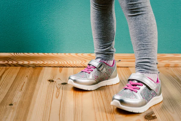 Child in sneakers on wooden background — Stock Photo, Image