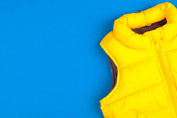 Żółta kurtka dla dzieci izolowana na niebieskim tle — Zdjęcie stockowe