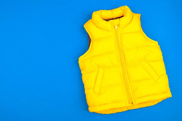 Жовта дитяча куртка ізольована на синьому фоні — стокове фото