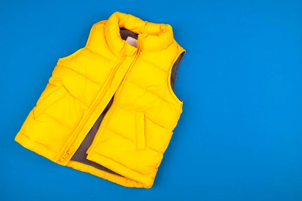 Yellow kids jacket isolated on blue background — 스톡 사진