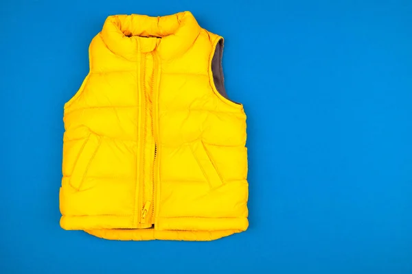 Yellow kids jacket isolated on blue background — 스톡 사진