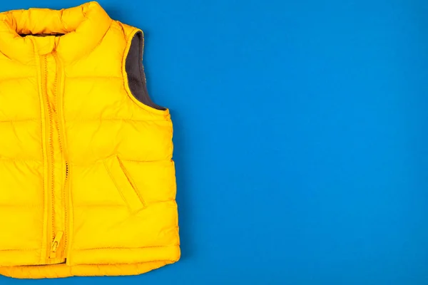 Yellow kids jacket isolated on blue background — 스톡 사진