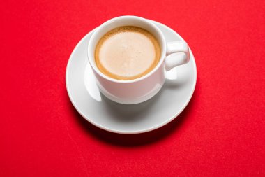 Black coffee in a cup on a red background