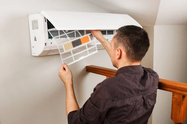 Manlig tekniker rengöring luftkonditionering inomhus — Stockfoto