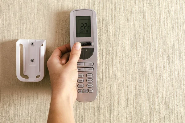 Hand with air conditioner remote control — 스톡 사진