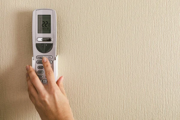 Hand with air conditioner remote control — 스톡 사진