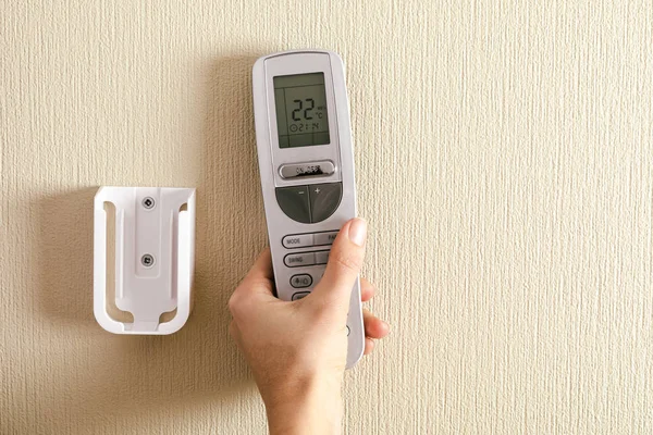 Hand with air conditioner remote control — 스톡 사진