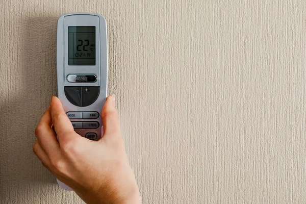 Hand with air conditioner remote control — 스톡 사진