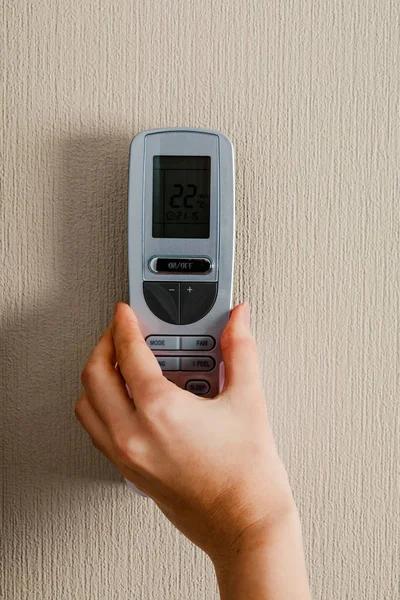 Hand with air conditioner remote control — 스톡 사진