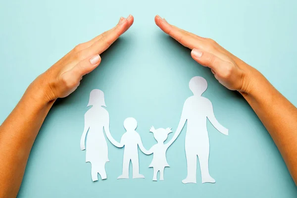 Familia de papel en mano aislada sobre fondo azul — Foto de Stock