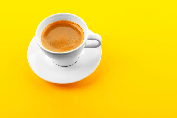 Schwarzer Kaffee in einer Tasse auf gelbem Hintergrund — Stockfoto