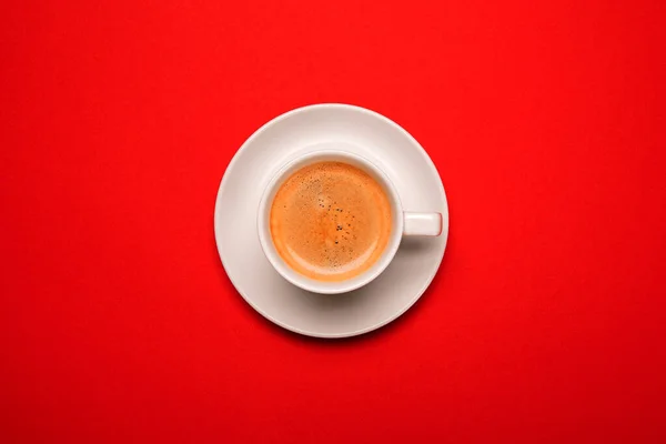 Schwarzer Kaffee in einer Tasse auf rotem Hintergrund — Stockfoto