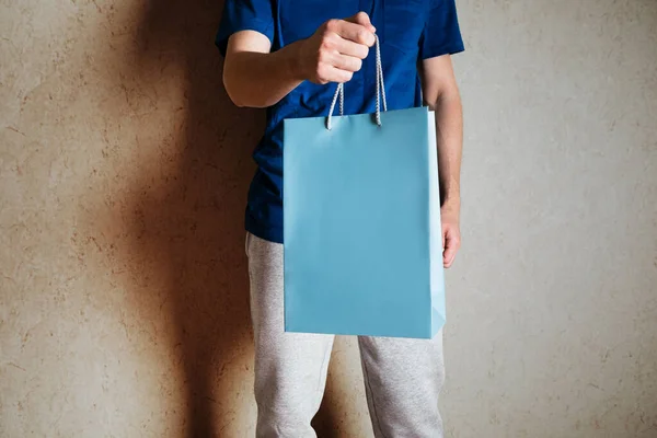 Man Houdt Een Papieren Zak Zijn Hand Een Rode Achtergrond — Stockfoto