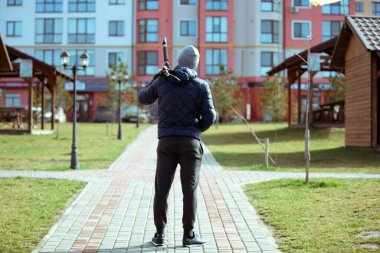 Üç ayaklı fotoğrafçının silueti. Genç adam şehirde kamerasıyla fotoğraf çekiyor.. 