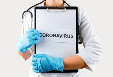 Beyaz üniformalı kadın doktor Coronavirus yazılı pano tutuyor. 2019-nCoV.