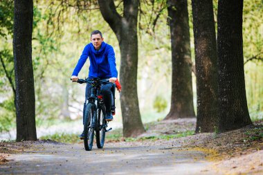 Ormanda neşeli bir aile bisikleti. Baba ve kız bisikletli.