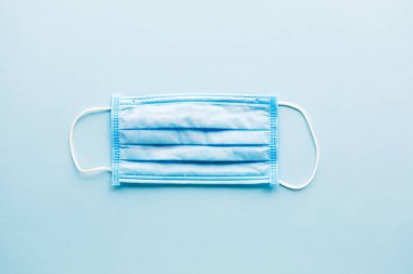 Koronavirüsü önle. Tıbbi maske, tıbbi koruyucu maske mavi arka planda izole edilmiş..