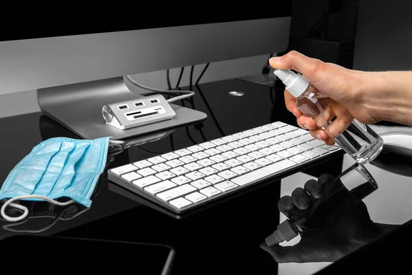 disinfection of a computer keyboard with an antiseptic. Disinfecting workplace concept.