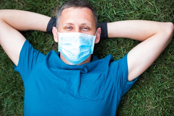 Young Man Face Medical Mask Lies Green Grass Resting Self — Stock Photo, Image