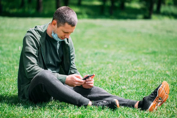 Tabiat maskeli bir adam. Adam COVID-19 karantinasından sonra parkta dinleniyor.