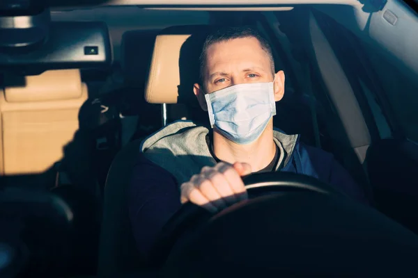 Man in the medical mask in car. coronavirus, disease, infection, quarantine, covid-19