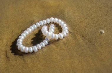 Deniz kum üzerinde inci boncuklar