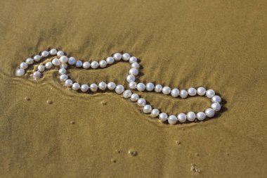 Deniz kum üzerinde inci boncuklar