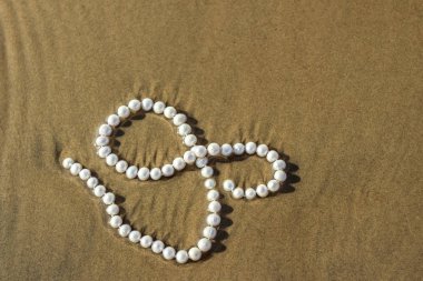 Deniz kum üzerinde inci boncuklar
