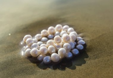 Deniz kum üzerinde inci boncuklar