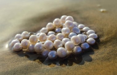 Deniz kum üzerinde inci boncuklar