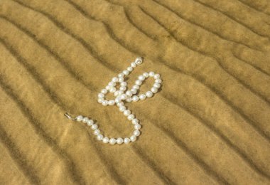 Deniz kum üzerinde inci boncuklar