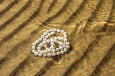 Deniz kum üzerinde inci boncuklar