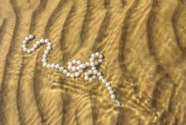 Deniz kum üzerinde inci boncuklar