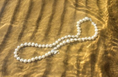 Deniz kum üzerinde inci boncuklar