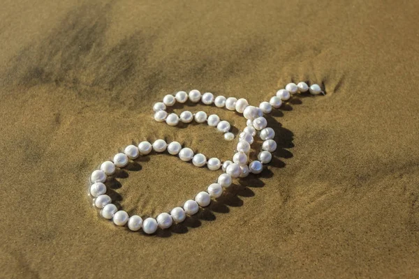 Cuentas de perlas en la arena del mar — Foto de Stock