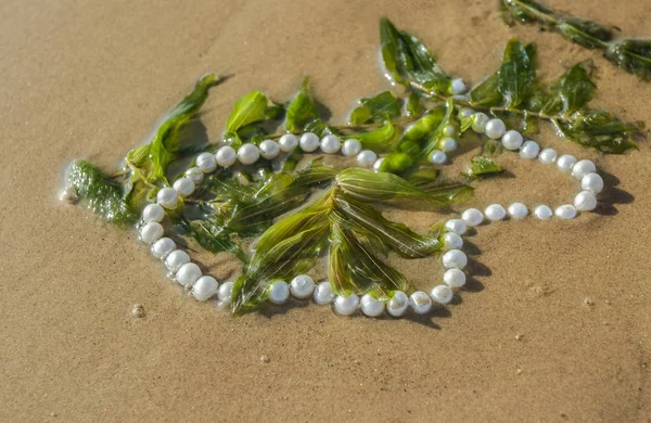 Cuentas de perlas en la arena del mar — Foto de Stock