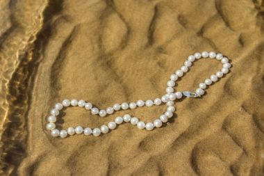 Deniz kum üzerinde inci boncuklar