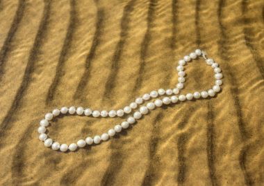 Deniz kum üzerinde inci boncuklar