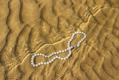 Deniz kum üzerinde inci boncuklar