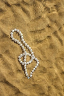 Deniz kum üzerinde inci boncuklar