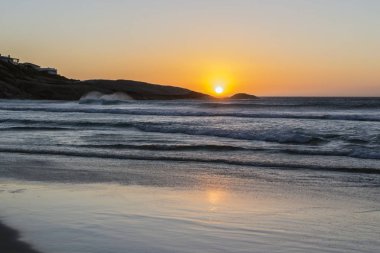 Güney Afrika, Cape Town. Sandy beach, Lundadno batan güneşin ışınları defne